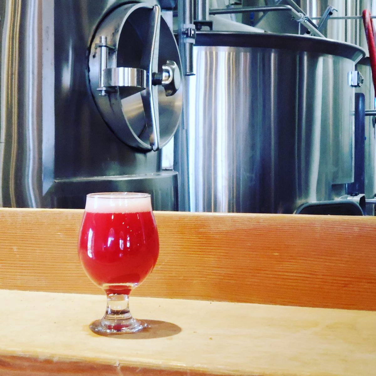 tombstone brewing passion fruit raspberry berliner pink in a glass in the brewery