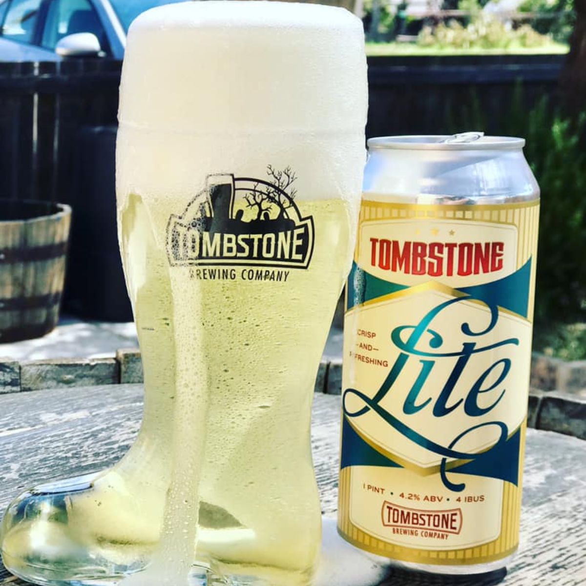 tombstone lite beer in a pint and can outside in the sun