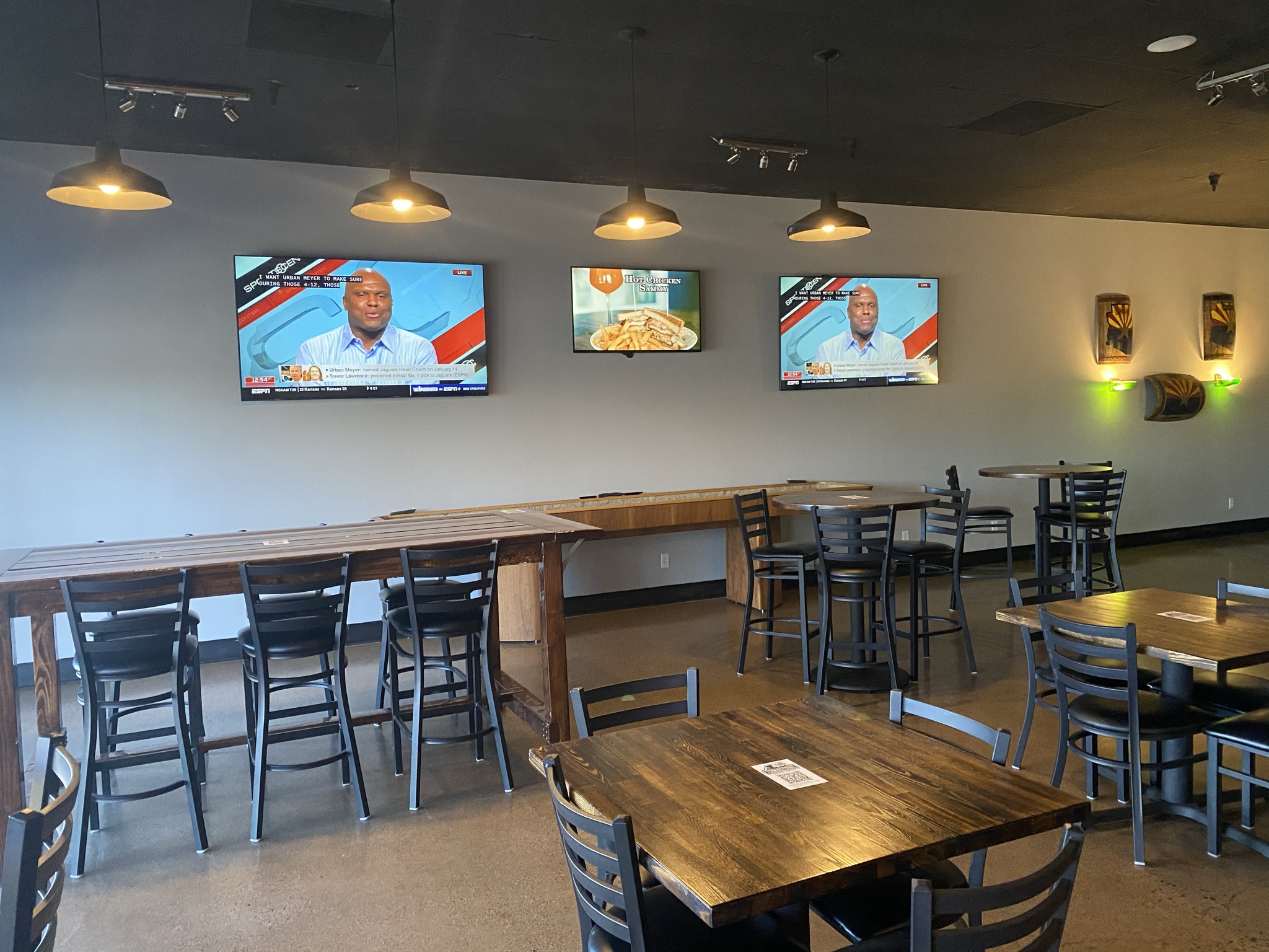 tombstone brewing interior with tvs on the wall, shuffle board, and tables
